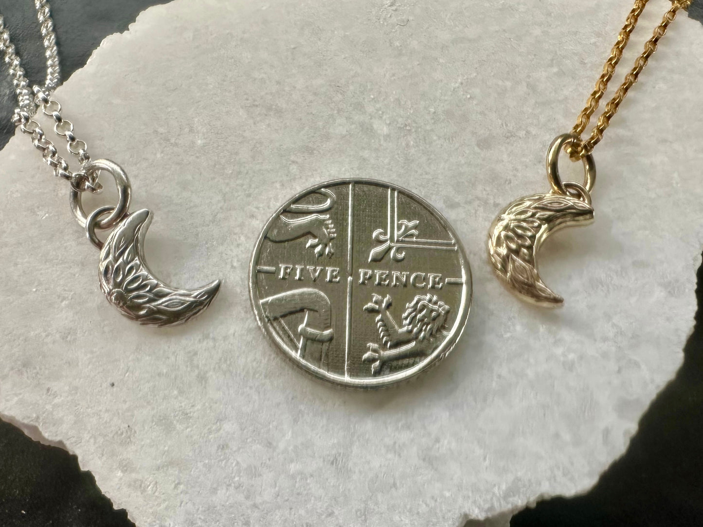 Handmade crescent moon charm size comparison against 5 pence piece